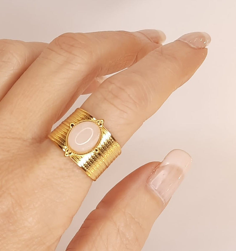 Bague ajustable en acier inoxydable Anneau large finement ciselé, serti d'un cabochon de pierre fine rose Largeur de l'anneau1.4cm En vogue ! Ce bijoux résiste à l'eau, l'humidité..., ne noircit pas, il est hypoallergénique. Il a fait l'objet de contrôle qualité par nos soins. Il gardera son éclat. Cette bague est livrée dans un pochon en velours, avec un chiffon de polissage.