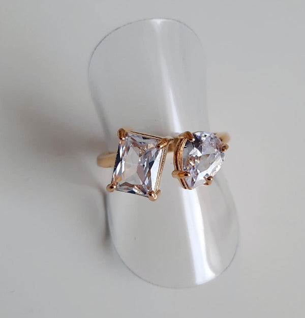      Bague dorée, réglable en acier inoxydable     Anneau qui est orné de deux oxydes de zirconium, sertis par des griffes     Un zircon est rectangulaire, le second est ovale     Une splendeur !     Dans le même style    Ce bijoux résiste à l'eau, l'humidité..., ne noircit pas, il est hypoallergénique. Il a fait l'objet de contrôle qualité par nos soins. Il gardera son éclat. Cette bague est livrée dans un pochon en velours, avec un chiffon de polissage.