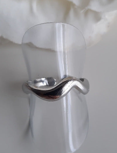     Bague argentée en acier inoxydable     Réglable     Anneau lisse en forme de vague     On aime la simplicité de ce bijoux que l'on peut facilement mélanger avec d'autres bagues de notre collection  Ce bijoux résiste à l'eau, l'humidité..., ne noircit pas, il est hypoallergénique. Il a fait l'objet de contrôle qualité par nos soins. Il gardera son éclat. Cette bague est livrée dans un pochon en velours, avec un chiffon de polissage.