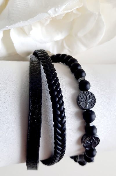 Bracelet en cuir et pierres naturelles Composé de trois rangs. Deux rangs en cuir, un lisse et le second tressé. Le modèle noir a un rang en pierres volcaniques noires et trois médailles en acier ornées d'un arbre de vie Fermoir aimanté en acier inox Le modèle marron a ses pierres en œil de tigre et trois médailles en acier ornées d'un arbre de vie.